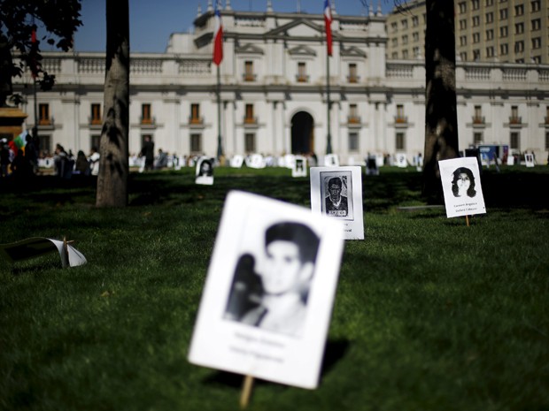 Fotos de vítimas da ditadura de Augusto Pinochet são espalhadas em frente ao palácio presidencial, em Santiago, na sexta (11), data do 42º aniversário do golpe que depôs o presidente Salvador Allende (Foto: Reuters/Ivan Alvarado)